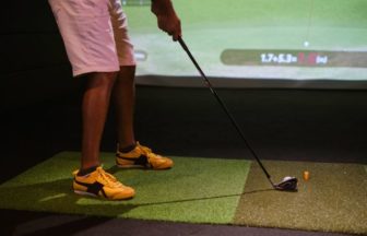 ゴルフスクールで練習をする男性